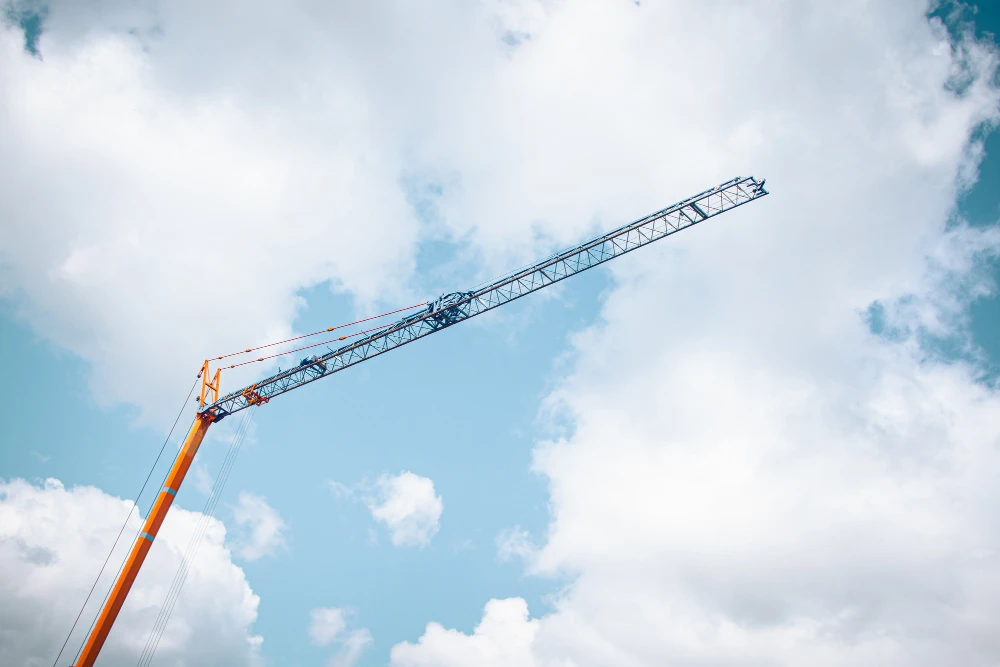Imagem de um guindaste de torre utilizado na construção civil, destacando a importância de evitar os 6 erros comuns na escolha de barramentos para pórticos.